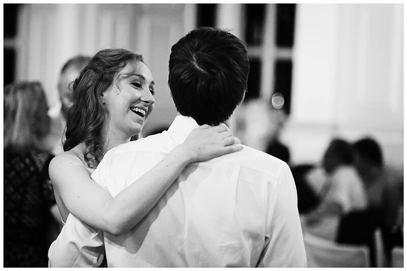 smiling female guest hugs boyfriend on dance floor 