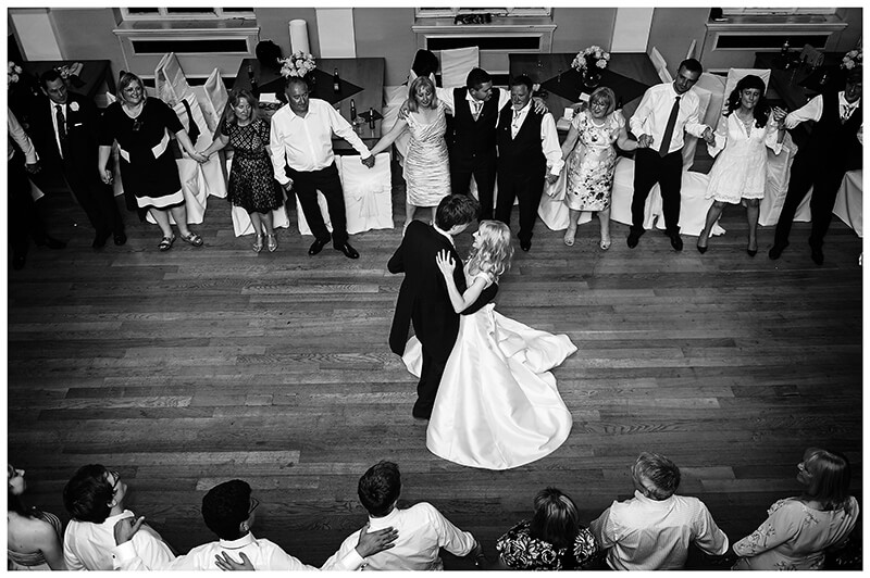 Bride groom on dance floor surrounded by guests