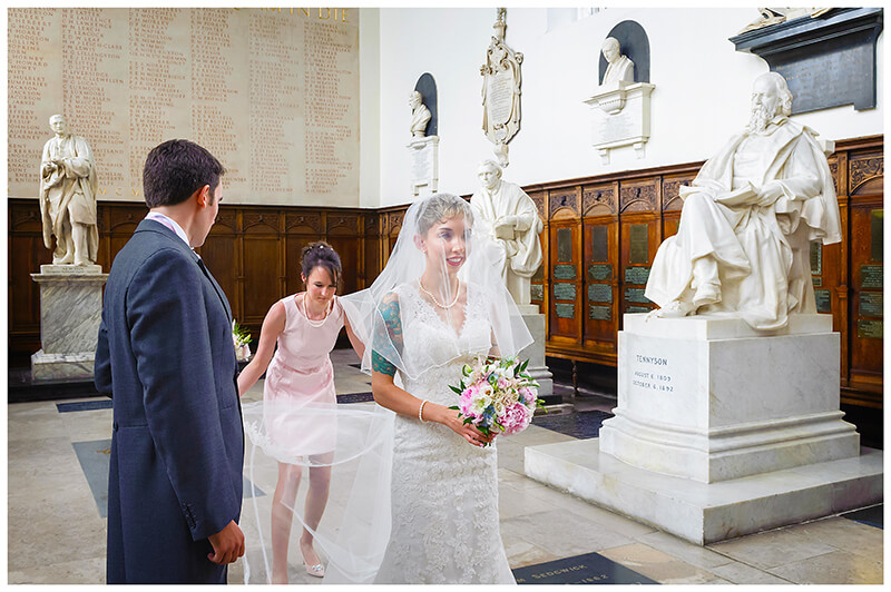 bridesmaid alters brides veil prior to entering Trinity College chapel