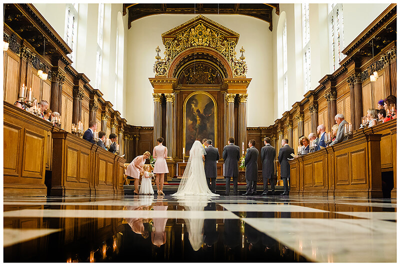 bridal party reflected in chequered floor of Trinity College chapel