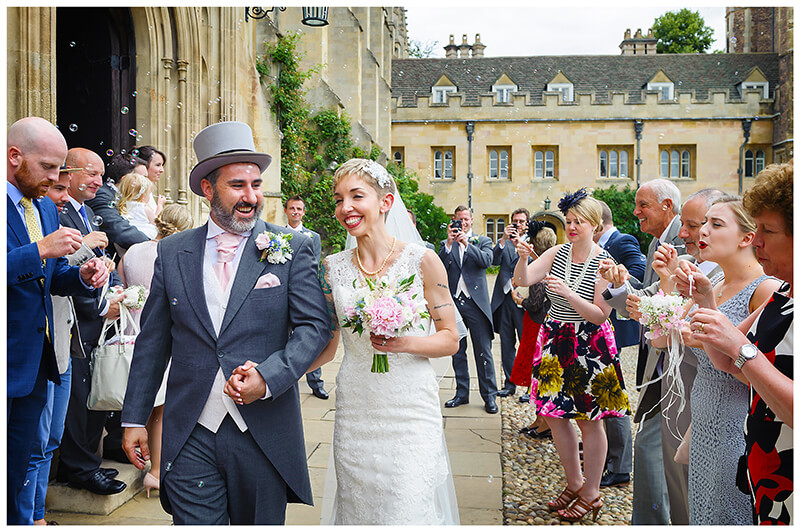 smiling bride & groom during confetti throwing at Trinity College wedding