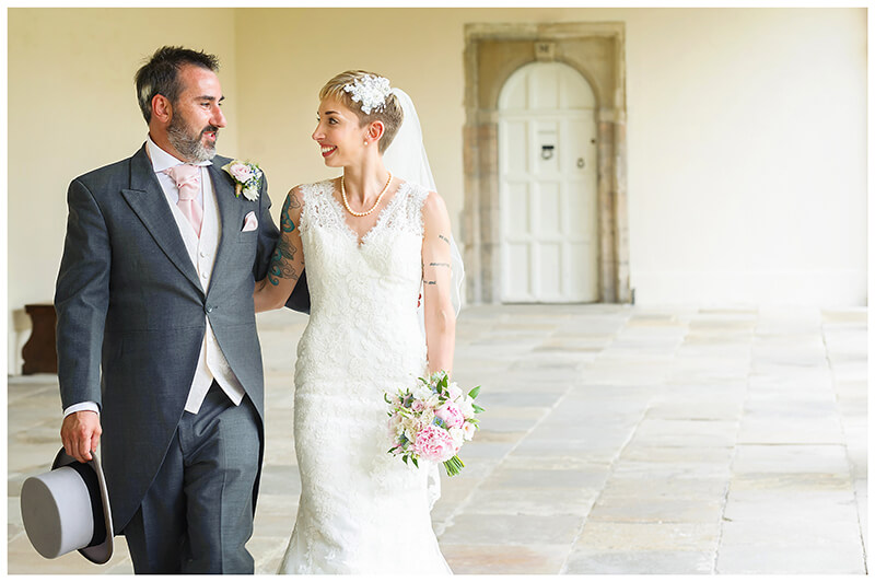 white door behind bridal couple as they walk arm in arm at Trinity College wedding