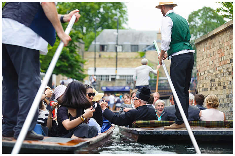 vicar shakes tourist hand whilst riding in punt on river cam