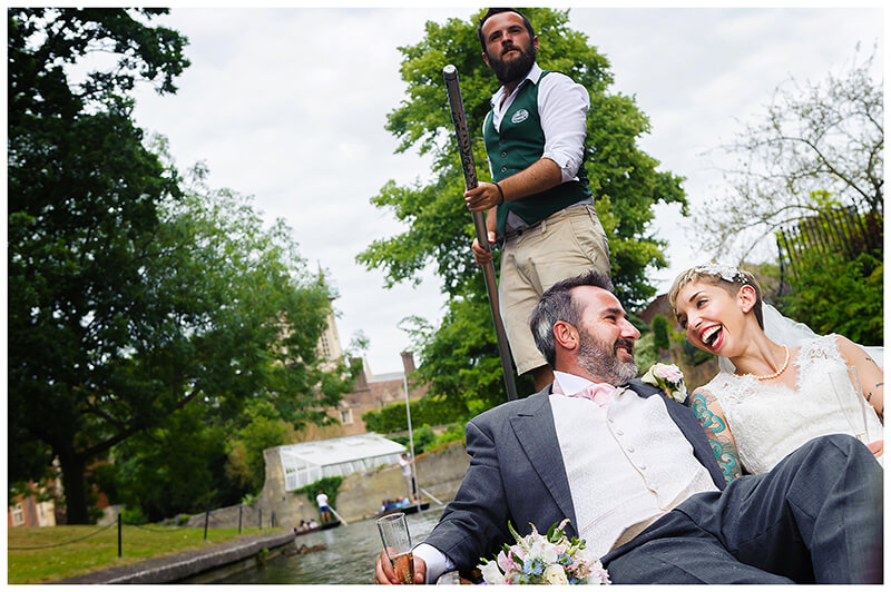 laughing bride and groom riding on a punt