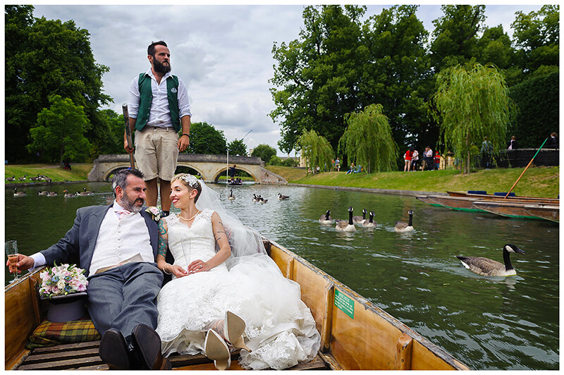 bride and groom in a punt on the river cam followed by geese