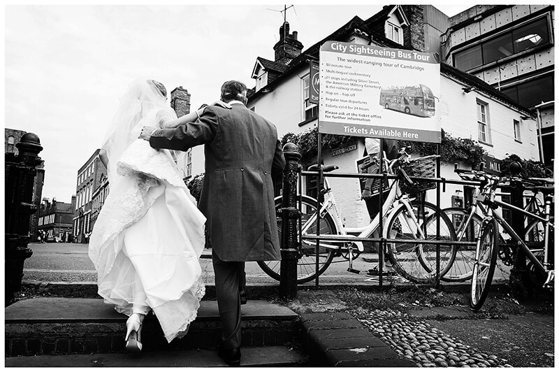Cambridge College Wedding Groom helps bride up steps
