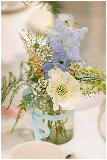 Wedding decorations blue & white flowers in small jars on tables