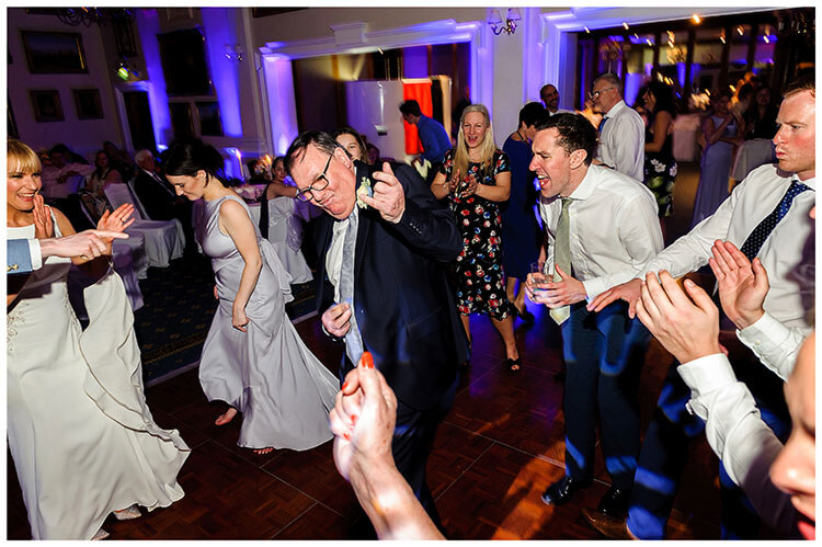 Wentworth Club Surrey dad playing an imaginary guitar on the dance floor guests cheering him on