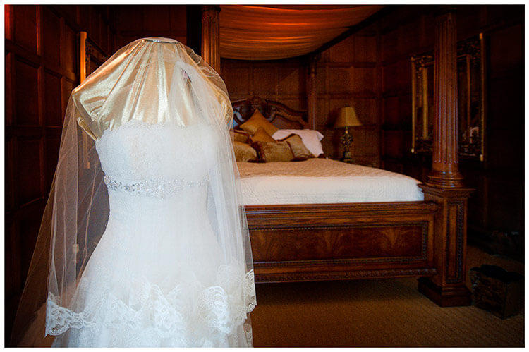 hengrave hall wedding bridal dress on manikin in front of four poster bed 