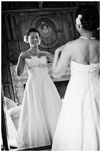 hengrave hall wedding bride in front of mirror adjusting dress