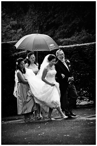 hengrave hall wedding bridal party under umbrella