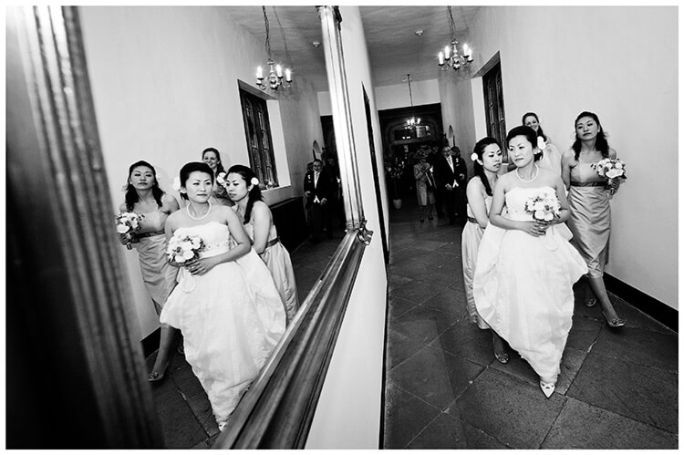 hengrave hall wedding bride bridesmaids reflection walking down corridor