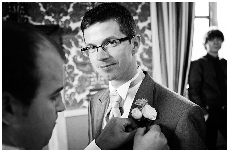 groom button hole flower being fixed
