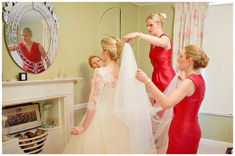Leicestershire Kirby Muxloe wedding bride has veil fitted by bridesmaid reflected in mirror