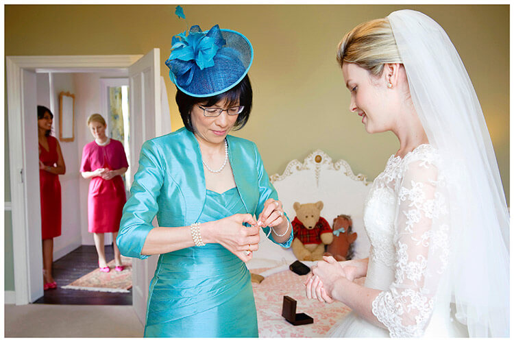 Leicestershire Kirby Muxloe wedding lady in blue gives bride present as bridesmaids watch