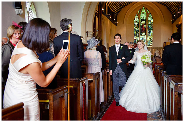 Leicestershire Kirby Muxloe wedding bride groom walking down aisle guest takes photo on phone