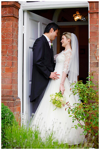 Leicestershire Kirby Muxloe wedding smiling bride and groom standing in doorway