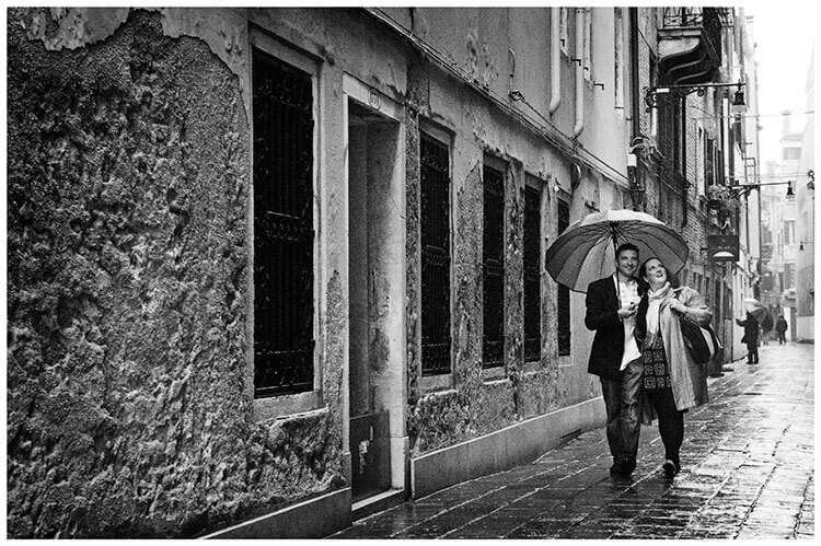 Venice Post Wedding Shoot photography couple holding umbrella gaze at buildings