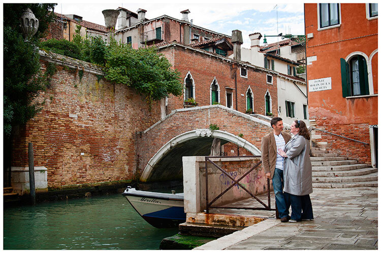 Venice Post Wedding Shoot photography couple embrace next to bridge over canal