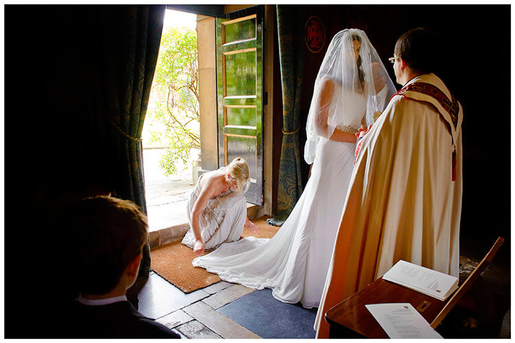 Christ’s College wedding bride talks to vicar bridesmaid adjusts dress little boy watches