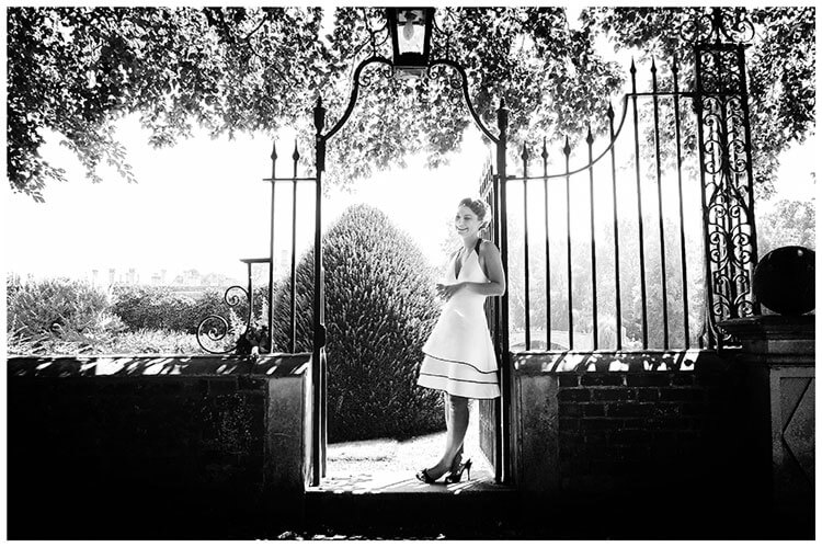 Choosing your perfect wedding photographer bride standing in gate way smiles