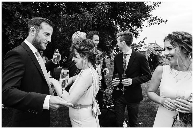 Adjusting his tie at Crishall Cambridgeshire garden Village wedding
