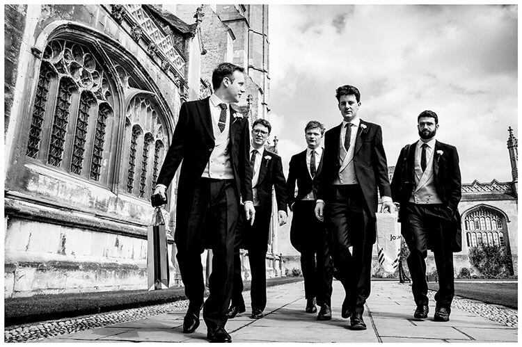 groom and groomsmen walking towards Kings College Chapel for the ceremony