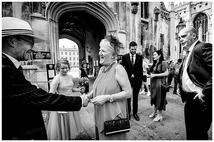 Guests greet each other outside Kings College Cambridge prior to wedding ceremony