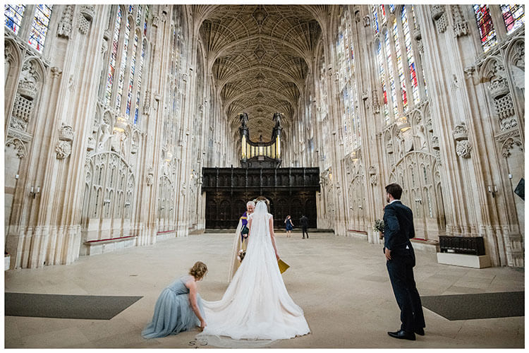 Wedding guests arrive late as bride has her wedding dress adjusted before walking up the aisle at Kings college Cambridge Chapel favourite wedding photography 2018