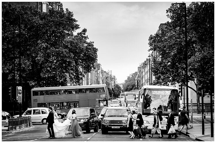 Bridal party cross road as cars wait and bus passes in background during London wedding favourite wedding photography 2018