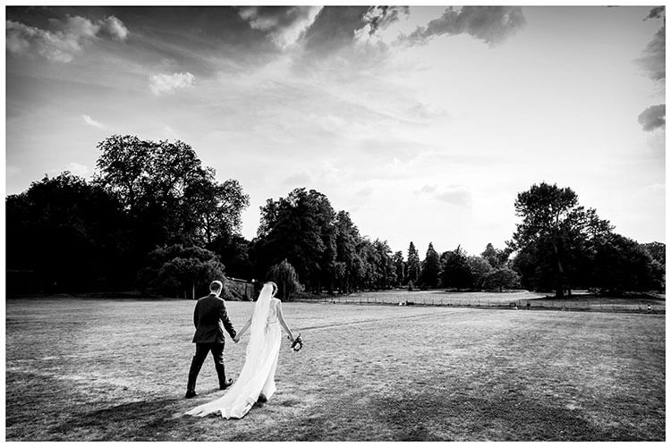 Bride and groom walking hand in hand through the grounds of Kings College Cambridge favourite wedding photography 2018